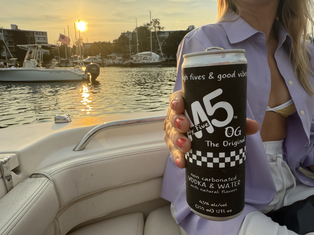 Girl holding OG Can on boat in harbor